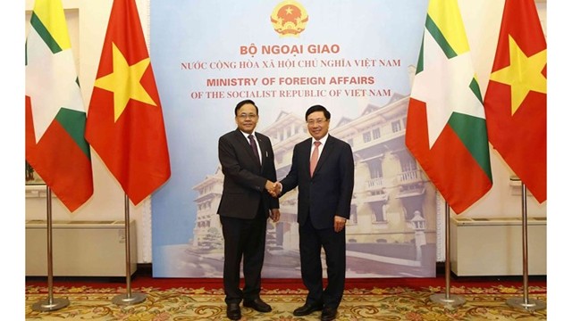 越南政府副总理兼外长范平明与缅甸国际合作部部长吴觉丁握手。