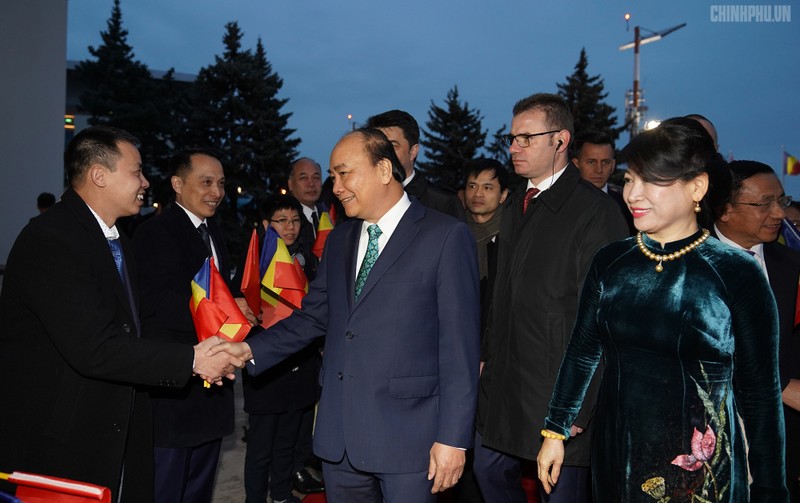 阮春福总理与前来机场迎接的旅罗越南人社团代表握手。