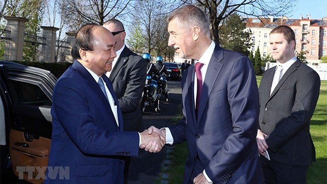两位总理亲切握手。（图片来源：越通社）