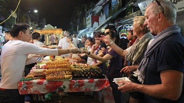 外国游客在河内夜市购买。
