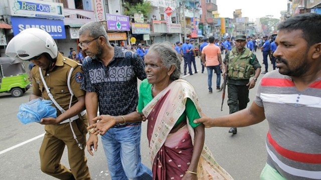 4月21日发生爆炸之后，一位斯里兰卡妇女在教堂外边得到帮助。