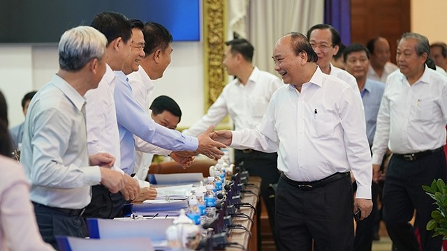 越南政府总理阮春福与参会代表握手。（图片来源：VGP）
