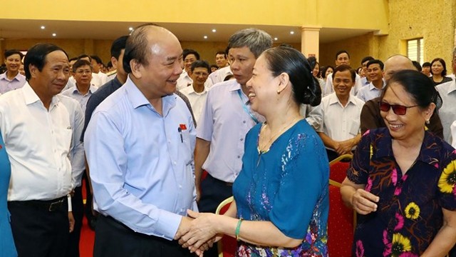 越南政府总理阮春福与见瑞县选民握手。（图片来源：越通社）
