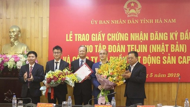 河南省领导给两大投资项目颁发投资许可证。