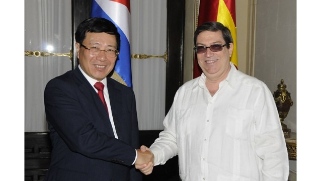 越南政府副总理兼外交部长同古巴外交部长握手。（图片来源：世界与越南报）