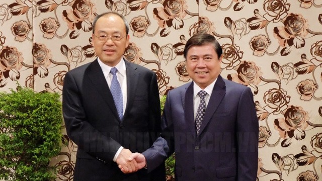 胡志明市人民委员会主席阮诚峰与中国云南省省长阮成发握手。