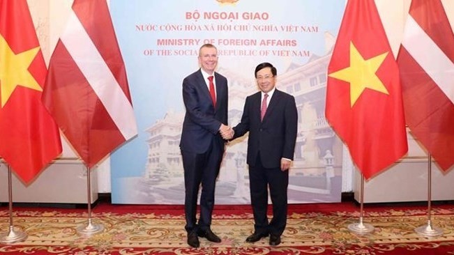 越南政府副总理兼外长范平明与拉脱维亚外长林克维奇斯。（图片来源：越通社）