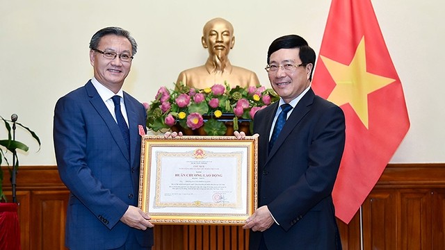 政府副总理兼外交部长范平明向老挝驻越南大使通沙万•丰威汉授予一级劳动勋章。（图片来源：VGP）