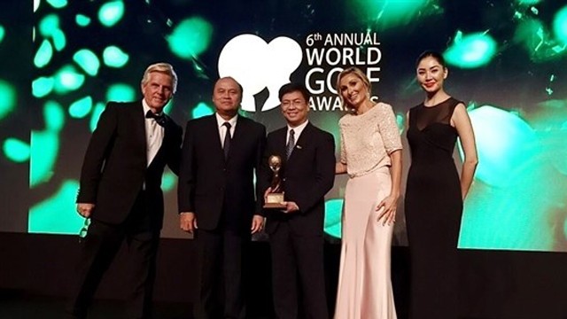 越南旅游总局旅游市场司司长丁玉德（中）在第六次世界高尔夫球奖颁奖仪式上接收奖项。
