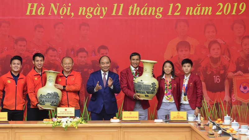 越南政府总理阮春福对荣获第30届东运会冠军的越南男女足球队予以表彰。（陈海 摄）