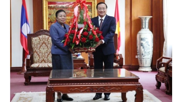 老挝人民革命党中央对外部部长顺通•赛雅佳（左）庆祝越南共产党建党90周年。