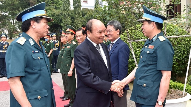 阮春福总理与越南防空空军军种司令部干部握手。（陈海 摄）