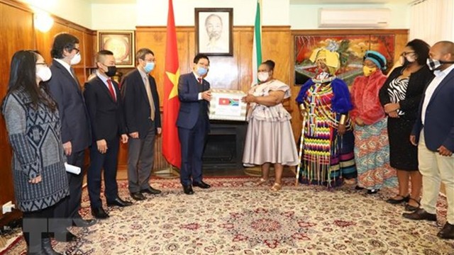 越南驻南非大使馆代表向姆比扎纳地方自治市市长移交礼物。（图片来源：越通社）