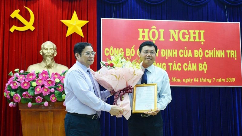 越共中央组织部部长范明正向阮进海同志授予决定书。