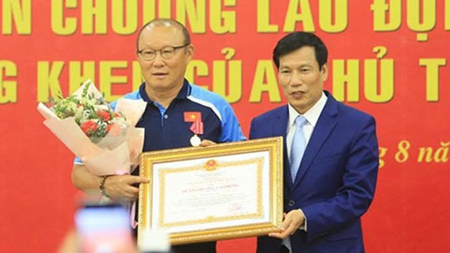 阮玉善部长给朴恒绪主教练颁发二级劳动勋章。
