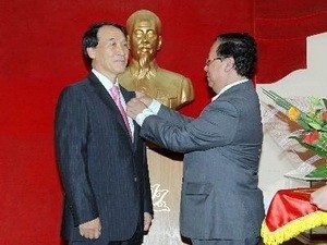 越南友好组织联合会主席武春鸿向何赞虎大使授予纪念章。