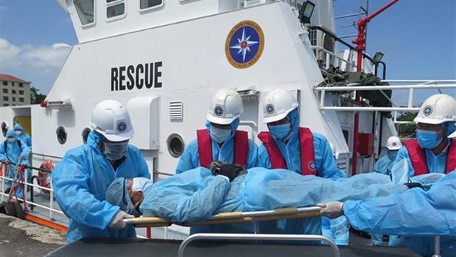越南航海救援力量将一名外国船员送上岸接受治疗。