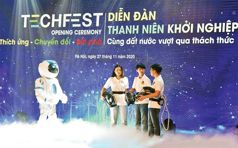 2020年青年论坛开幕式上的机器人与越南防疫帽子Vihelm制造小组之间的对话。（德英 摄）