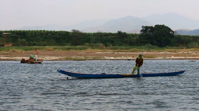 老挝渔民在湄公河上捕鱼。