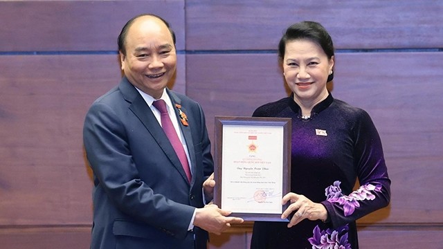 国会主席阮氏金银向政府总理阮春福颁发纪念章。（图片来源：越通社）