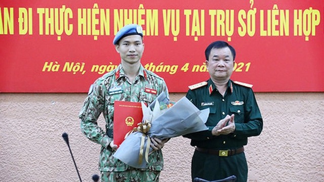 黄春战副部长向阮福东少校颁发决定书。