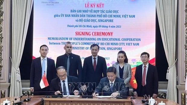胡志明市人委会副主席杨英德（右）和新加坡驻胡志明市总领事Ray Kho签署关于胡志明市与新加坡教育部建立合作关系的协议。