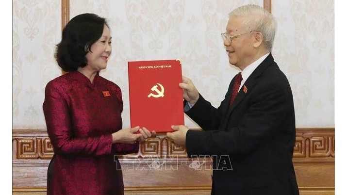 越共中央总书记阮富仲向张氏梅同志颁发决定。