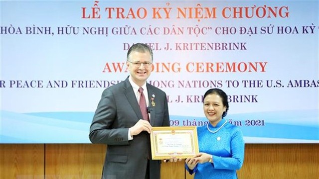 越南友好组织联合会主席阮芳娥向美国驻越大使丹尼尔•克里滕布林克授予“致力于各民族和平友谊”纪念章。