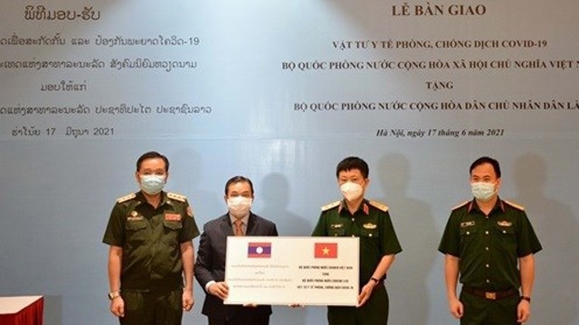 越南国防部外事局局长武战胜中将象征性地向老挝国防部代表移交医疗防疫物资。