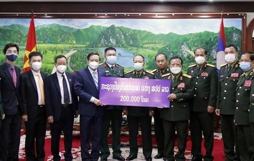 老挝国防部部长占沙蒙•占雅拉向越南驻老大使阮伯雄移交捐款。（图片来源：越通社）