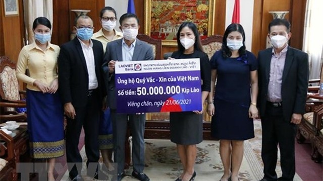 老越联营银行代表向越南新冠疫苗基金会捐赠 5000万基普。（图片来源：越通社）