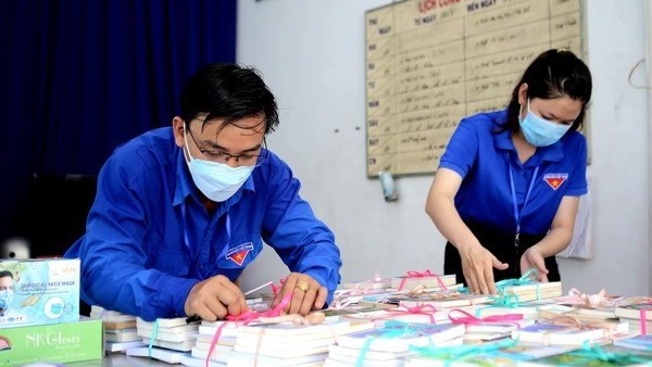 胡志明市富润郡工会干部为封锁区人民准备图书。（图片来源：越通社）