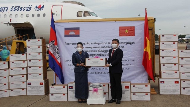 柬埔寨卫生部国务秘书尤克·桑巴斯（左）移交柬方捐赠的防疫物资 。