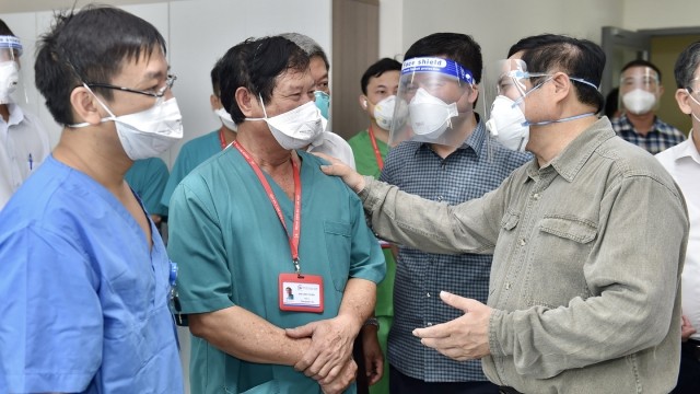 范明正总理与Becamex综合医院医生们交谈。（图片来源：卫生部官网） 