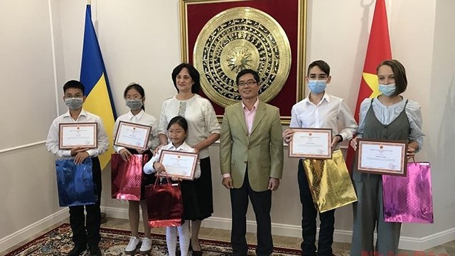 阮宏石大使向学生们颁发奖状和礼物。