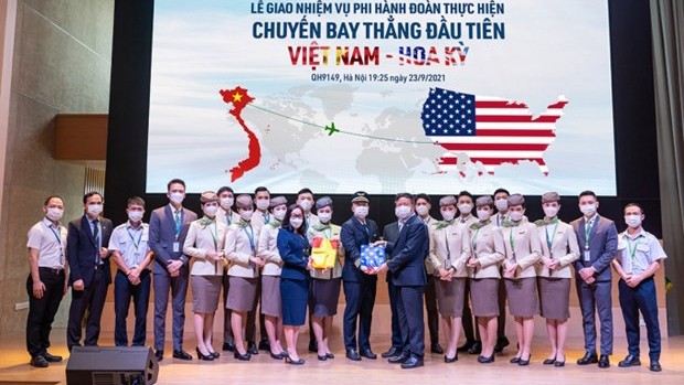 越南FLC集团总经理裴海玄向机组人员移交国旗。（图片来源：越通社）