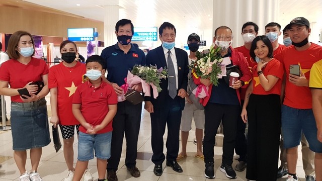 越南驻阿联酋大使阮孟俊向越南男足队赠送鲜花。