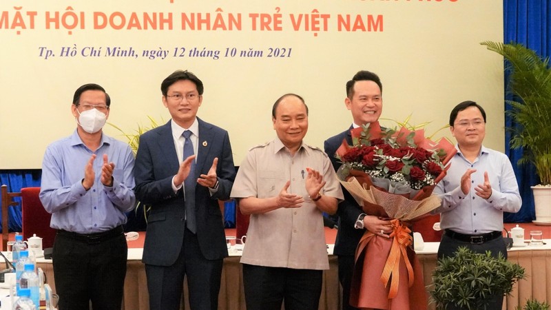 国家主席阮春福赠送鲜花祝贺越南青年企业家。（图片来源：青年报网）