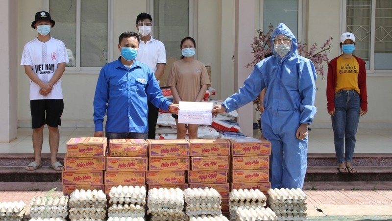旅居老挝越南人向因受新冠肺炎疫情影响陷入困境的人赠送慰问品。（图片来源：VOV）