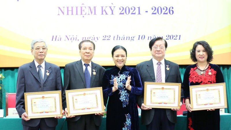 越南友好组织联合会主席阮芳娥大使向越朝友好协会优秀个人授予“致力于各民族和平友谊”纪念章。