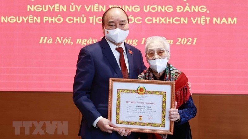 国家主席阮春福向原国家副主席阮氏萍授予党龄75年纪念章。（图片来源：越通社）
