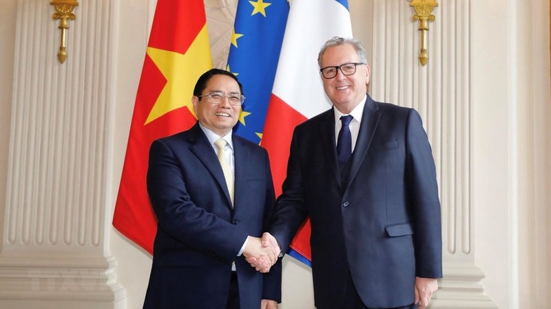 越南政府总理范明正与法国国民议会议长费朗握手。（图片来源：越通社）