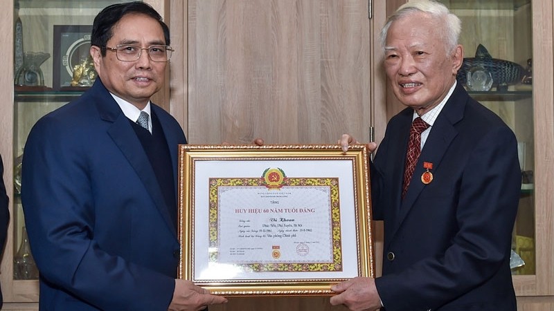 政府总理范明正向前政府副总理武宽授予60年党龄纪念章。