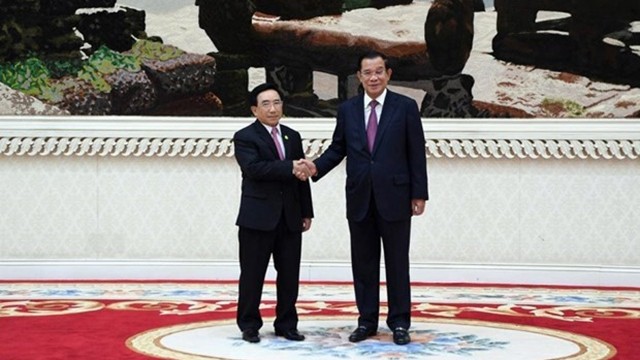 老挝政府总理潘坎·维帕万与柬埔寨首相洪森握手。