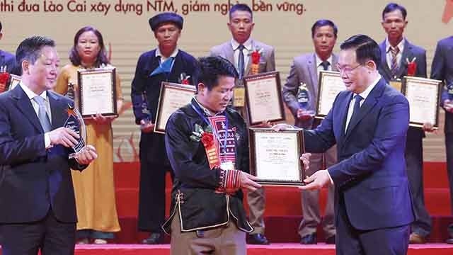 越南国会主席王廷惠向优秀农民颁发了2021年优秀农民荣誉证书。（图片来源：越通社）