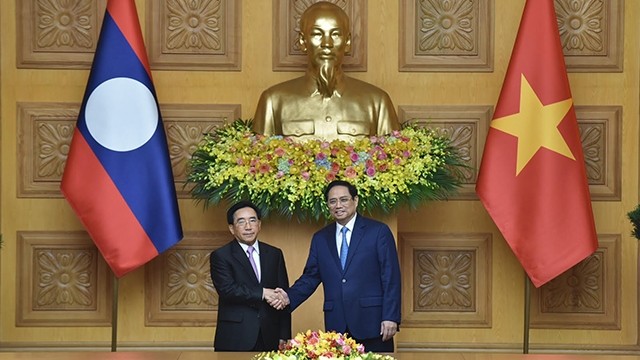 范明正总理与老挝政府总理潘坎·维帕万握手。（陈海 摄）