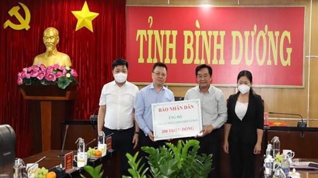 黎国明总编辑代表《人民报》社捐赠2亿越南盾助力平阳省疫情防控。