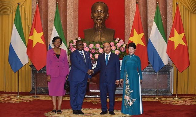 越南国家主席阮春福携夫人与塞拉利昂共和国总统朱利叶斯·马达·比奥携夫人合影。（图片来源：陈海 摄）