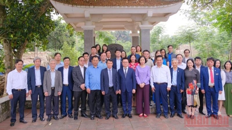 越南新闻工作者协会代表团在越南新闻工作者协会成立之地的国家级历史遗迹合影。（图片来源：人民报网）