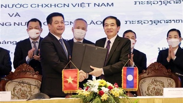越南工贸部部长阮鸿延与老挝工贸部部长坎培•赛宋培互换合作备忘录。（图片来源：越通社）